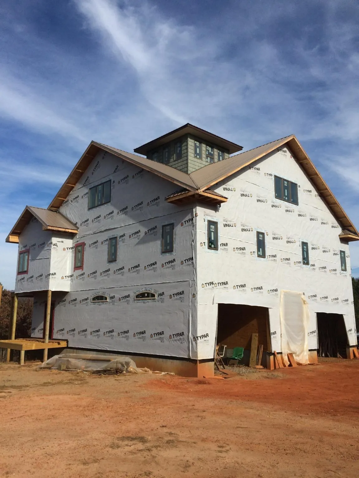 New two story house under construction with a cupola and gabled roofs in Utica